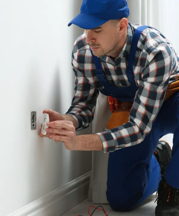 an emergency electrician working on fixing a wall socket or outlet